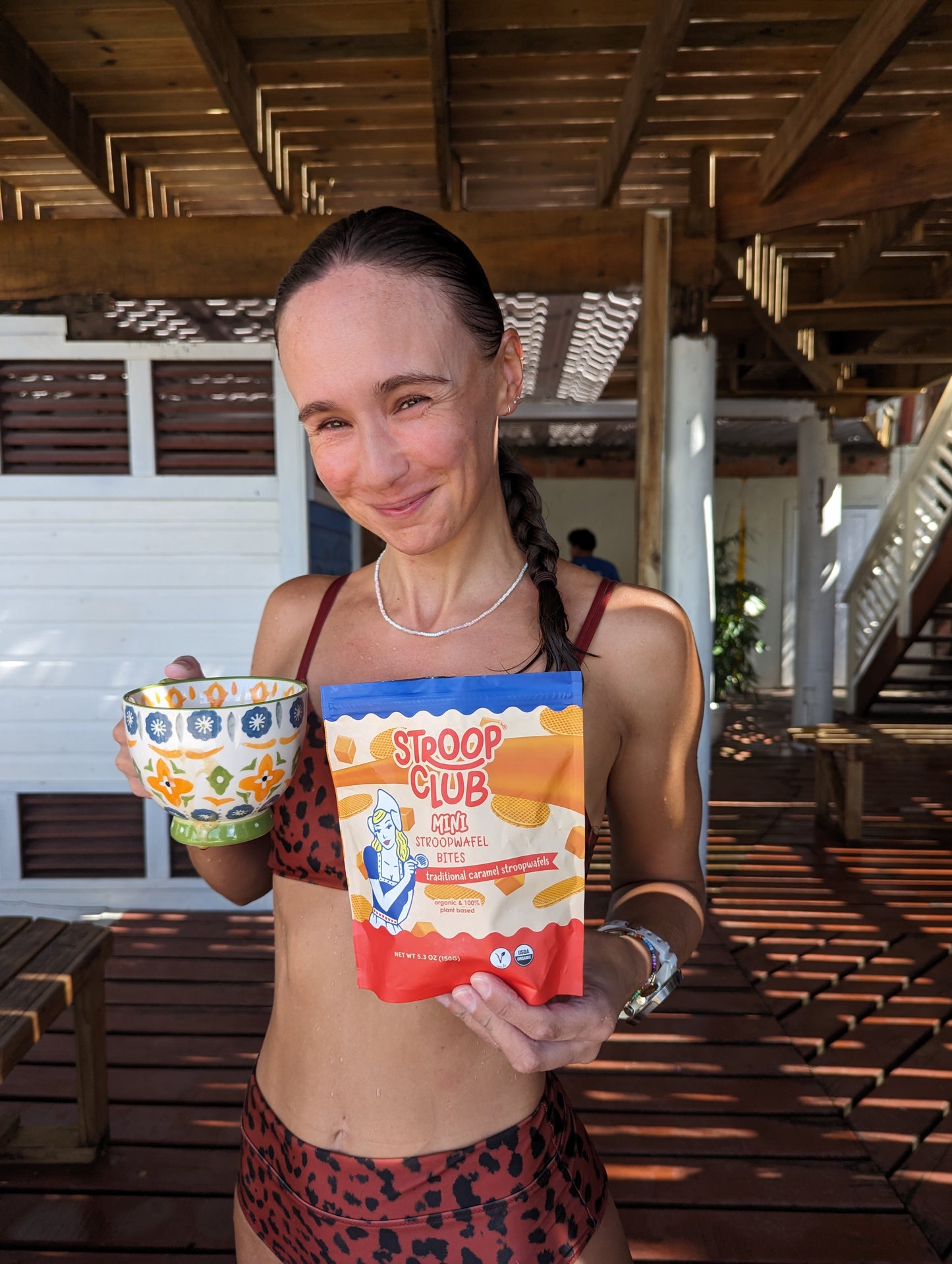 Photo of our friend holding a bag of mini stroopwafels in tropical surroundings.