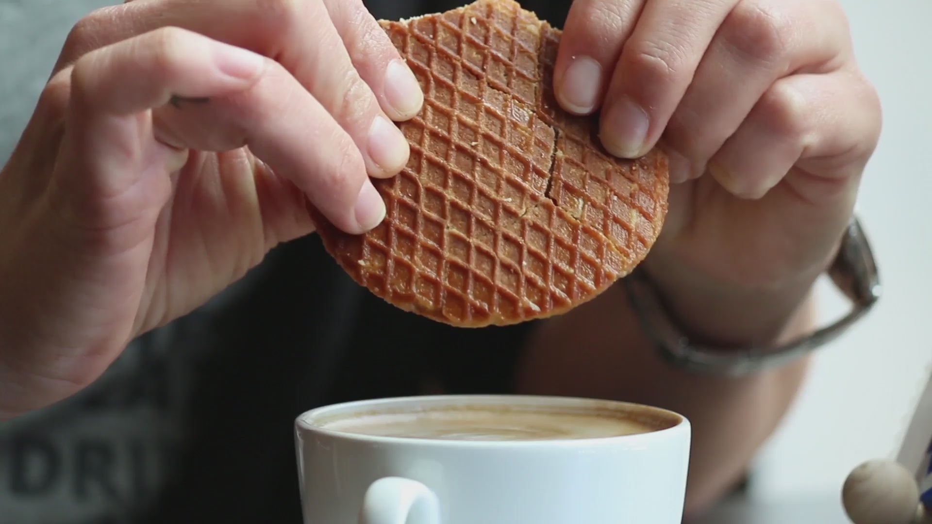 Load video: Video of a stroopwafel being broken in two above a cup of coffee, showing the caramel in the center.